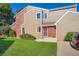 Attractive two-story townhouse with red front door and manicured green lawn in a sunny setting at 7476 E Arkansas Ave # 35-10, Denver, CO 80231