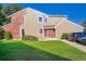 Charming townhouse featuring a well-maintained lawn, red door, and a blend of brick and siding exterior at 7476 E Arkansas Ave # 35-10, Denver, CO 80231