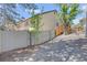 Side view of a house with gravel, fencing, trees and stairs leading to a deck, offering a sense of privacy at 6054 S Akron Way, Greenwood Village, CO 80111