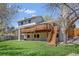 Spacious backyard features a two story deck, lush lawn, and mature tree, perfect for outdoor activities at 6054 S Akron Way, Greenwood Village, CO 80111
