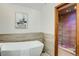 Bright bathroom featuring a modern soaking tub and walk-in shower with custom tile accents and stylish fixtures at 6054 S Akron Way, Greenwood Village, CO 80111