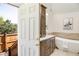Well-lit bathroom with modern fixtures, dual sinks, and a soaking tub visible through an open door at 6054 S Akron Way, Greenwood Village, CO 80111