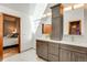 Bathroom featuring dual sinks, modern cabinets, and a view into an adjacent bedroom at 6054 S Akron Way, Greenwood Village, CO 80111