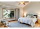 Bright bedroom featuring a large window, ceiling fan, hardwood floors, and a comfortable seating area at 6054 S Akron Way, Greenwood Village, CO 80111
