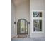 Grand front door with arched glass panels flanked by modern sconces and a side window at 6054 S Akron Way, Greenwood Village, CO 80111