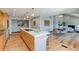 Open-concept kitchen has an island with a cooktop and leads to the dining and living areas at 6054 S Akron Way, Greenwood Village, CO 80111