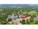 Aerial view of residential buildings surrounded by lush greenery and rolling mountains in the background at 850 W Moorhead Cir # 3L, Boulder, CO 80305