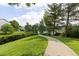Scenic view of a grassy path leading to a bridge, surrounded by mature trees and a serene lake at 850 W Moorhead Cir # 3L, Boulder, CO 80305