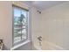 Bright bathroom with a soaking tub and a window overlooking the backyard deck at 6047 S Hill St, Littleton, CO 80120