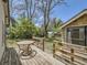 Backyard deck with a wicker table and stairs leading to the yard at 6047 S Hill St, Littleton, CO 80120