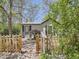 Charming home features a decorative fence, offering curb appeal and a cozy entrance from a shaded walkway at 6047 S Hill St, Littleton, CO 80120