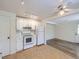 Classic white kitchen includes white appliances, fan, and track lights, adjoining the living area at 6047 S Hill St, Littleton, CO 80120