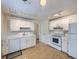 Bright kitchen features white cabinets, appliances, tile backsplash, and light wood floors at 6047 S Hill St, Littleton, CO 80120