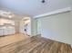 Bright living room featuring hardwood floors that transition to the adjacent kitchen with white cabinets at 6047 S Hill St, Littleton, CO 80120