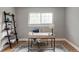 Bright office space with hardwood floors, large windows, desk, ladder bookshelf and area rug at 9290 Quitman St, Westminster, CO 80031