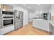 Modern kitchen featuring stainless steel appliances and white cabinetry at 13682 W Virginia Dr, Lakewood, CO 80228