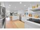 Modern white kitchen with stainless steel appliances and light wood floors at 13682 W Virginia Dr, Lakewood, CO 80228