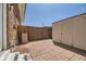 Private brick-paved backyard with wooden fence, storage shed, and string lights at 610 S Xenon Ct, Lakewood, CO 80228