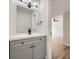 Updated powder room boasts a gray vanity with modern fixtures and a view to an adjacent room at 610 S Xenon Ct, Lakewood, CO 80228