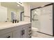This modern bathroom has a gray vanity, quartz countertop, black hardware, and a glass-enclosed shower at 610 S Xenon Ct, Lakewood, CO 80228