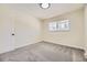 This bedroom is spacious and bright, with a large window, base-molding, neutral walls, and carpeted floors at 610 S Xenon Ct, Lakewood, CO 80228