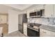 This kitchen offers stainless steel appliances, gray countertops, white cabinets and drawers, and a marble backsplash at 610 S Xenon Ct, Lakewood, CO 80228