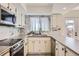 This updated kitchen has stainless steel appliances, gray countertops, white cabinets, and a marble backsplash at 610 S Xenon Ct, Lakewood, CO 80228