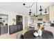 Stylish dining area with modern black chandelier, a black sideboard and a view into the adjacent kitchen at 11825 Meadowood Ln, Parker, CO 80138