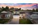 Beautiful home with a spacious driveway, lush green lawn, and a backdrop of mature trees at sunset at 11825 Meadowood Ln, Parker, CO 80138