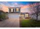 Charming two-story home with a well-manicured lawn, two car garage, and beautiful sunset backdrop at 11825 Meadowood Ln, Parker, CO 80138