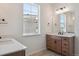 Bright bathroom featuring double sinks, light wood cabinets, and a large window with a view at 4729 Twelve Oaks Way, Castle Rock, CO 80104