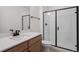 Bathroom featuring a white vanity with a black frame shower and a wood grain cabinet at 4729 Twelve Oaks Way, Castle Rock, CO 80104