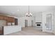 Open-concept living room with a fireplace, modern chandelier and access to kitchen, perfect for entertaining at 4729 Twelve Oaks Way, Castle Rock, CO 80104