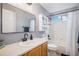 Modern bathroom with a single sink vanity and shower-tub combination with white tile surround and hardware at 11681 Night Heron Dr, Parker, CO 80134