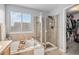 Elegant bathroom with a soaking tub and glass-enclosed shower featuring a tiled surround and storage niche at 11681 Night Heron Dr, Parker, CO 80134
