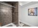 Tiled shower stall with built-in shelving, complemented by a colorful art piece on the wall at 11681 Night Heron Dr, Parker, CO 80134
