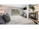 Cozy bedroom featuring a fireplace, a large window, and neutral-toned decor for a relaxing retreat at 11681 Night Heron Dr, Parker, CO 80134