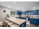 Stylish eat-in kitchen with custom blue cabinets, tile countertops, and stainless steel appliances at 11681 Night Heron Dr, Parker, CO 80134