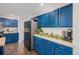 Well-lit kitchen featuring stylish blue cabinets, tile countertops, and stainless steel refrigerator at 11681 Night Heron Dr, Parker, CO 80134