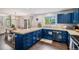 Modern kitchen and dining area with blue cabinets, tile countertops, and large windows at 11681 Night Heron Dr, Parker, CO 80134