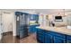 Spacious kitchen with custom blue cabinets, tile countertops, and stainless steel appliances at 11681 Night Heron Dr, Parker, CO 80134