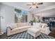 Bright living room featuring a large sectional sofa, a ceiling fan, and a big window with tree view at 11681 Night Heron Dr, Parker, CO 80134