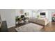 Open-concept living area featuring a wooden desk, plush rug, large sofa, and decorative wall art at 11681 Night Heron Dr, Parker, CO 80134