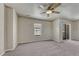 Bedroom featuring neutral carpeting, a ceiling fan, and sliding glass doors at 12833 Mayfair Way # F, Englewood, CO 80112