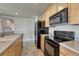 Spacious kitchen featuring wooden cabinets, black appliances, and tiled floors at 12833 Mayfair Way # F, Englewood, CO 80112