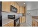 Kitchen with wooden cabinets, laminate countertops and black appliances at 12833 Mayfair Way # F, Englewood, CO 80112