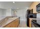 Kitchen featuring wooden cabinets, black appliances, a double basin sink and laminate countertops at 12833 Mayfair Way # F, Englewood, CO 80112