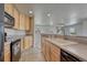 Bright kitchen featuring wood cabinets, tile flooring, and modern appliances at 12833 Mayfair Way # F, Englewood, CO 80112