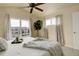 Bedroom featuring a ceiling fan and large windows offering picturesque views of the neighborhood pond at 15555 E 40Th Ave # 30, Denver, CO 80239
