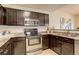Well-equipped kitchen with stainless steel appliances and dark wood cabinetry at 15555 E 40Th Ave # 30, Denver, CO 80239